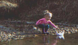Egy kislány talál a folyón egy papírhajót, amire az van ráírva: “Segíts nekünk”